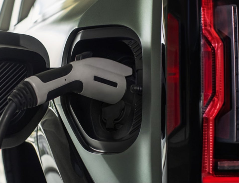 Close up of charging port with charger plugged in on a GMC Hummer EV SUV - Ellis GMC in Malone NY